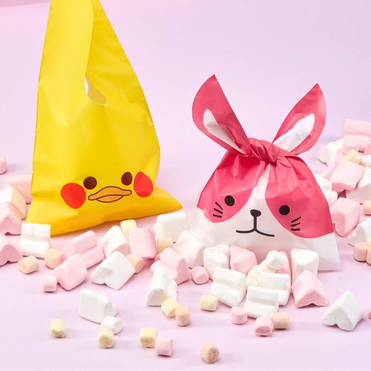 Busta per regalo pasquale a forma di papera e cane, caramelle vicino e sfondo rosa 