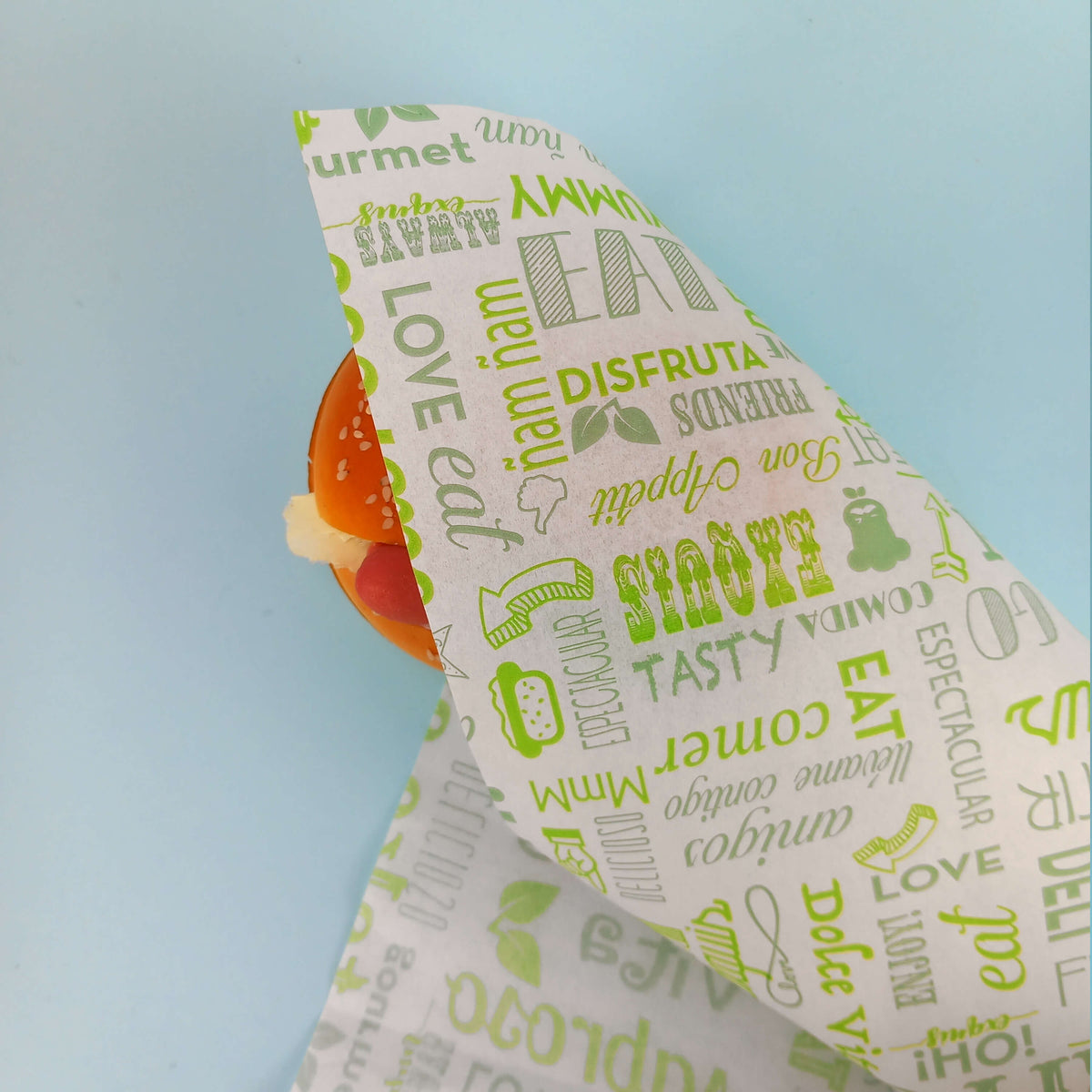 Carta alimentare bianca con scritte verdi attorno ad un panino 