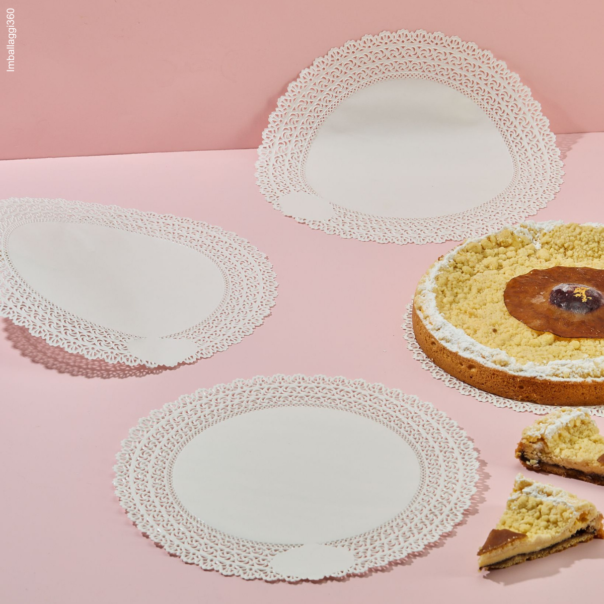 Carta pizzo rotonda, bianca, mostrata stesa e leggermente piegata accanto a torta e fette di torta