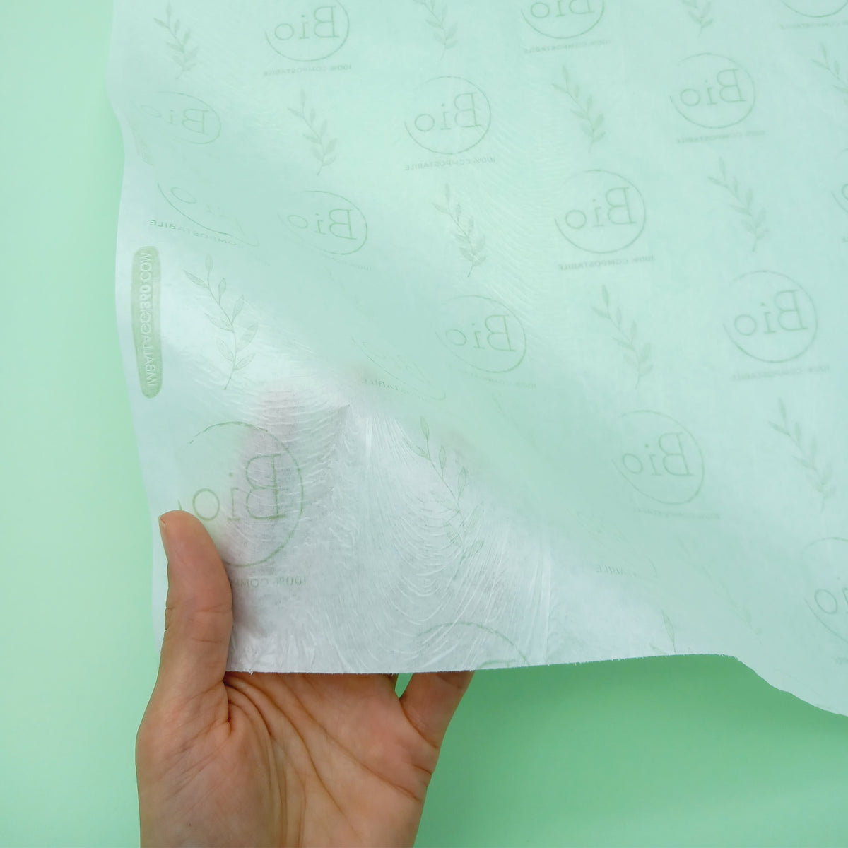 Carta politenata con loghi personalizzati. dettaglio retto da una mano 