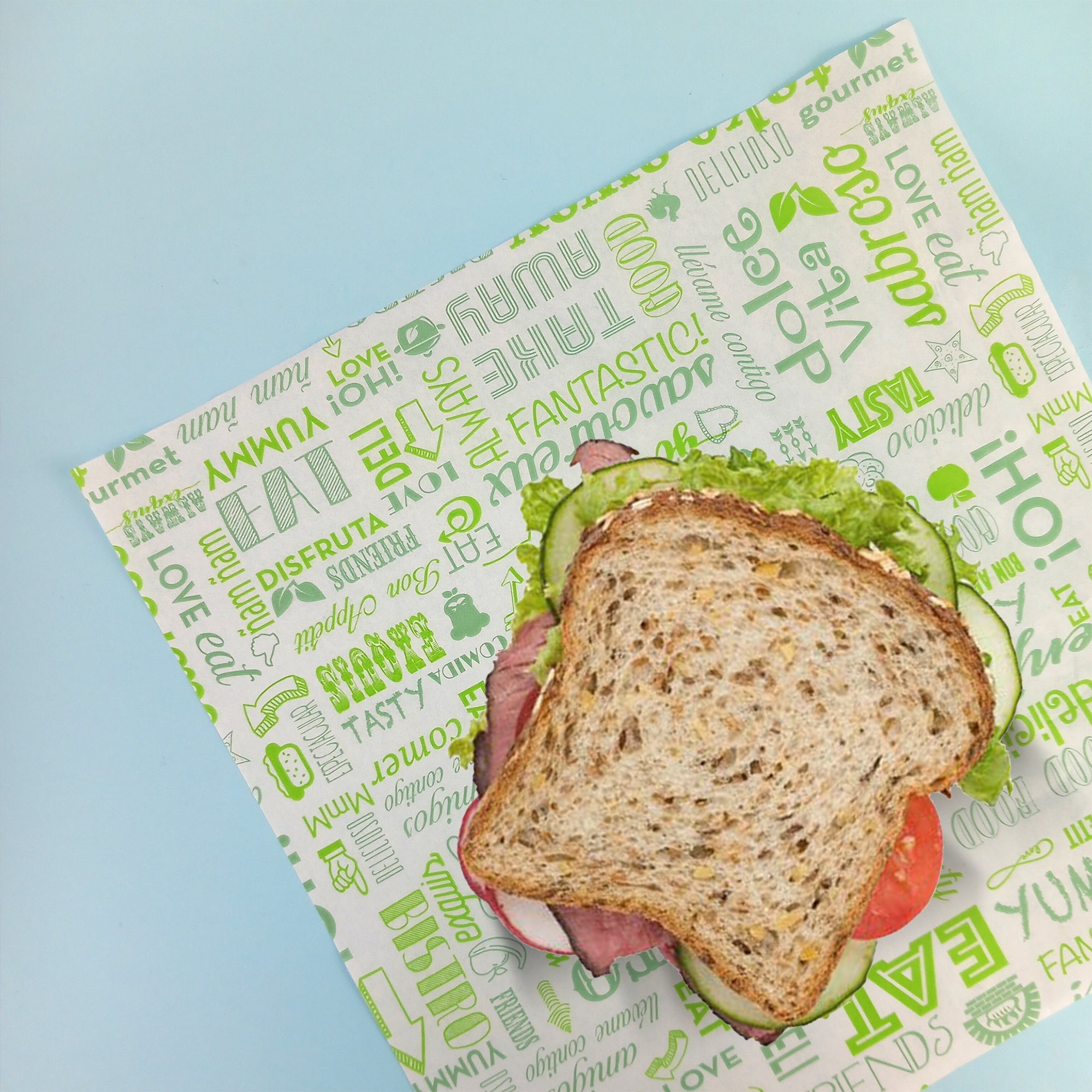 carta alimentare bianca con scritte verdi sotto ad un panino 