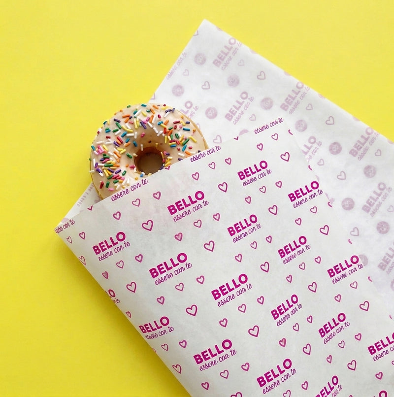 Carta pelleaglio bianca con scritta viola BELLO ESSERE CON TE che avvolge una ciambella colorata 
