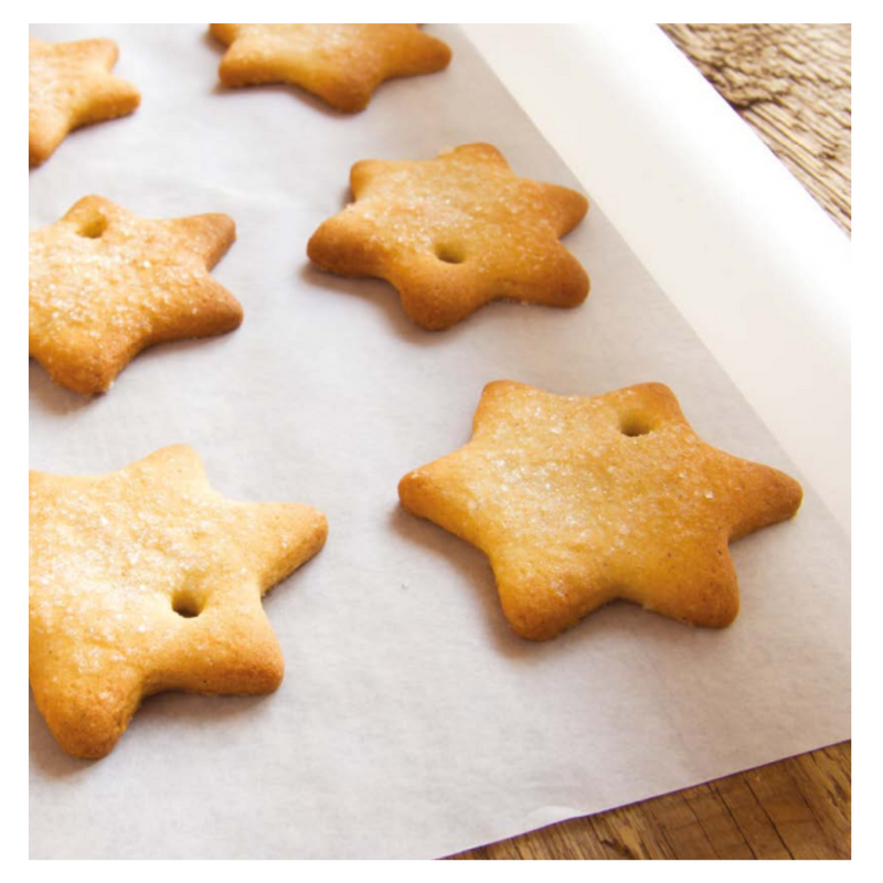 Biscotti a forma di stella su carta da forno bianca 