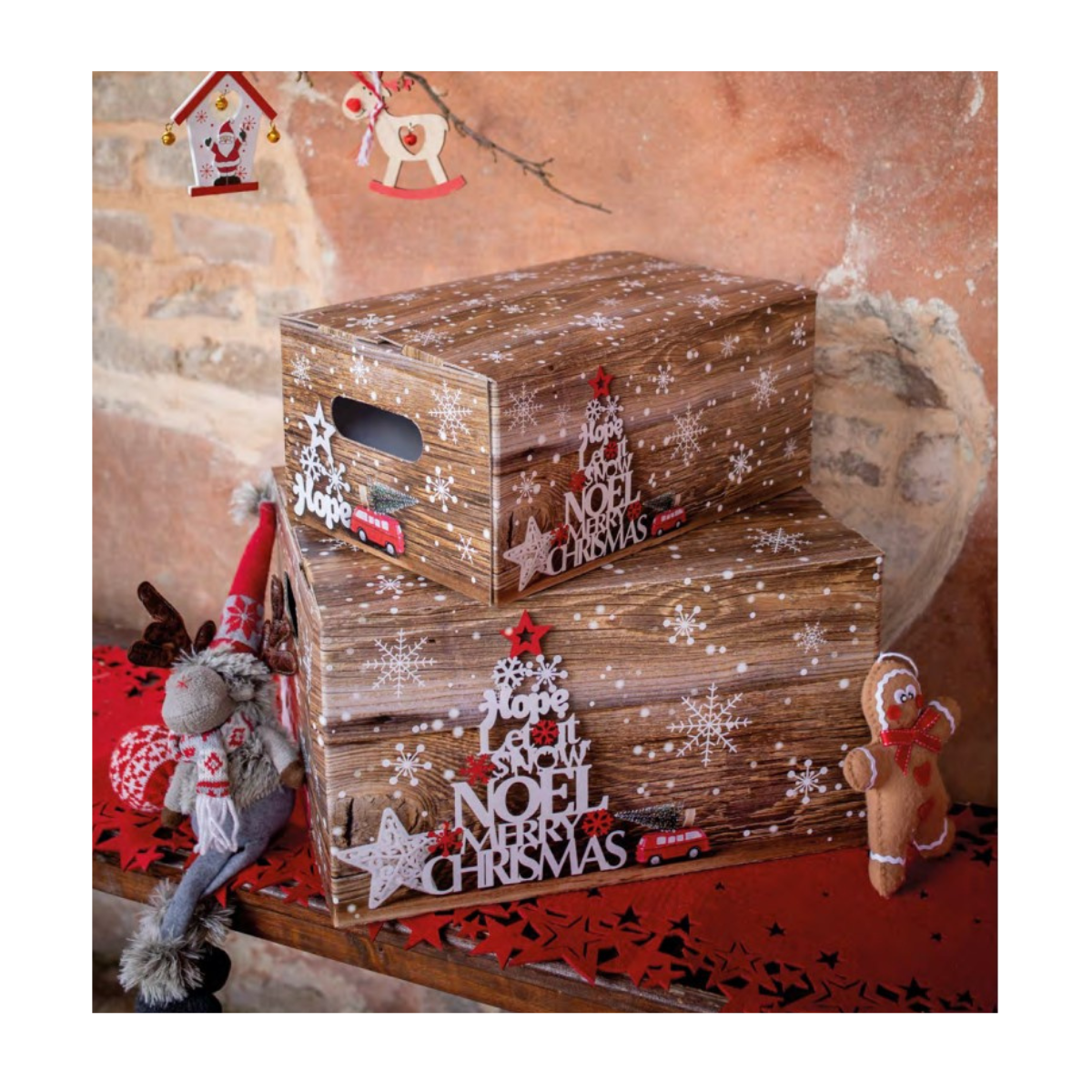 Scatole di cartone simil legno con addobbi e scritte natalizie su tavolo con tovaglia stelle rosse