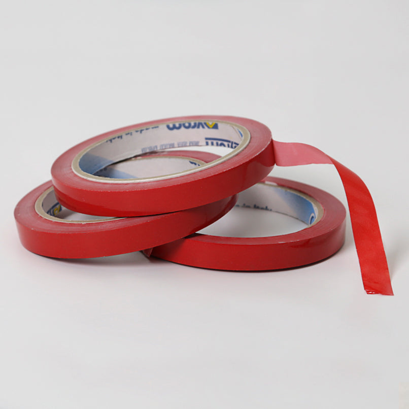 Tre rotoli di nastro adesivo rosso