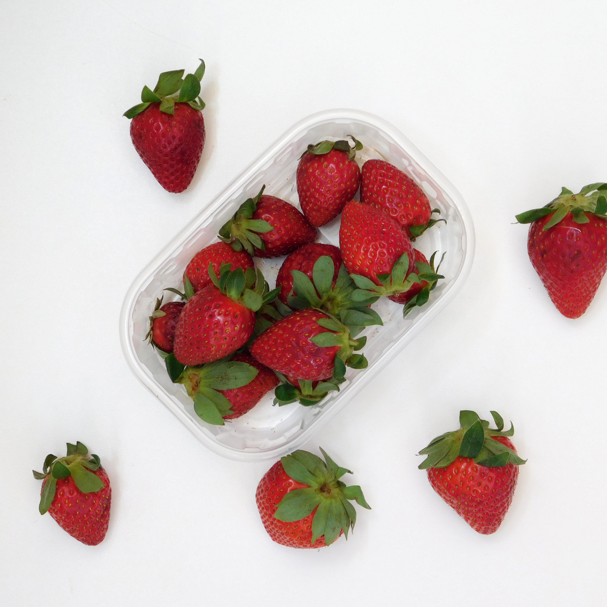 Cestello per frutta, con fragole, dentro e attorno, visto dall'alto