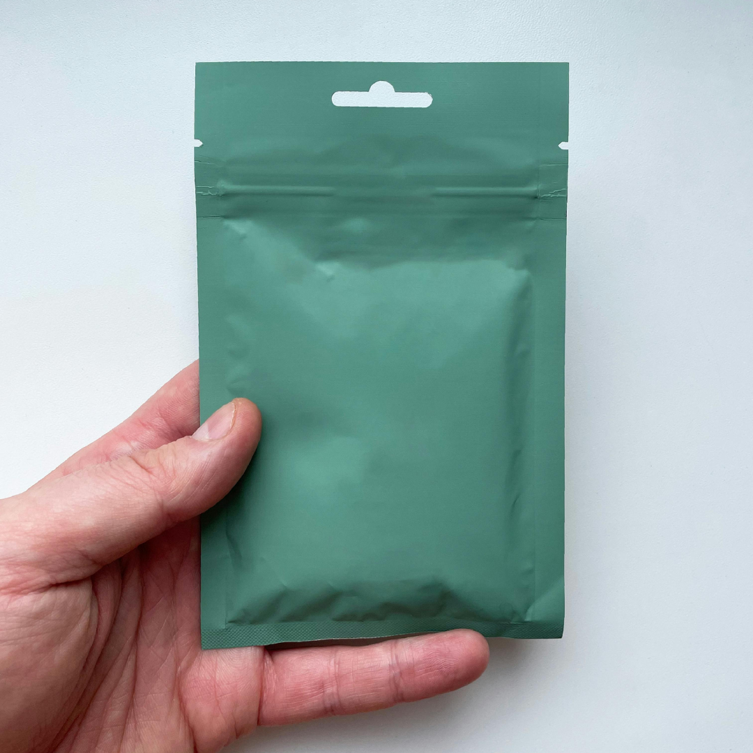 Busta verde tenuta da una mano 