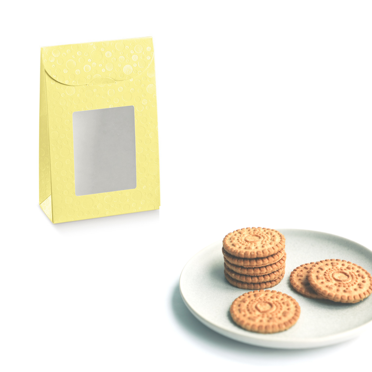Confezione di carta gialla con finestra vicino a piatto con dei biscotti 