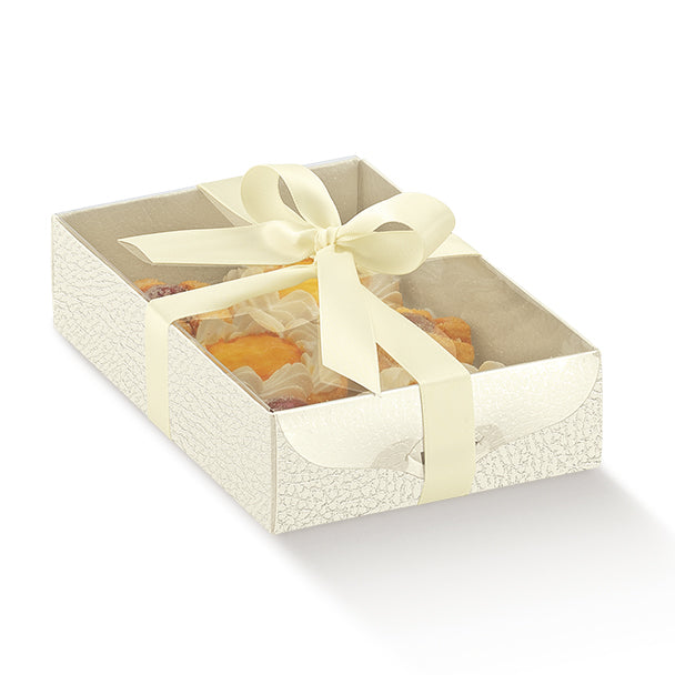Scatola bianca piena di dolci, con coperchio trasparente e fioco bianco
