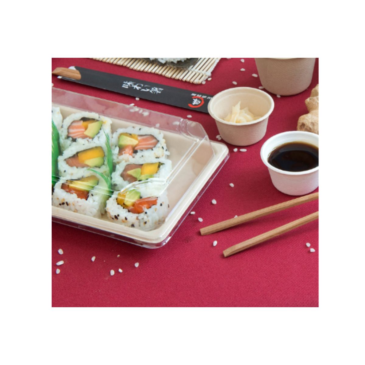 Confezione per sushi, piena, su tavola con elementi di cucina giapponese
