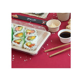 Confezione per sushi, piena, su tavola con elementi di cucina giapponese