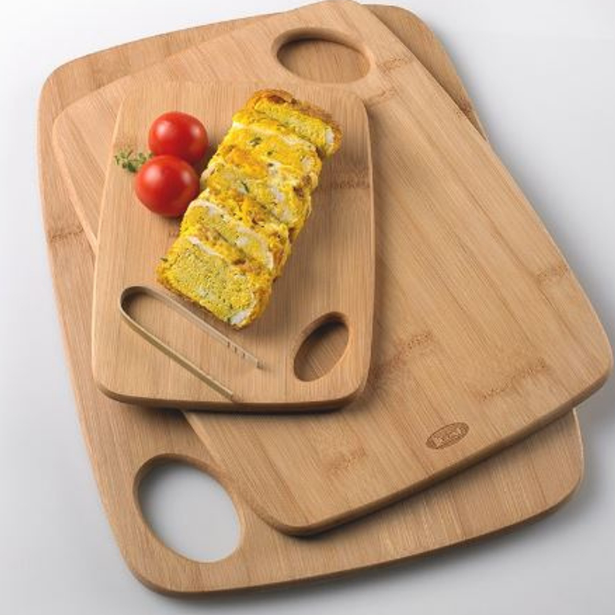 Taglieri di legno di diverse misure, impilati, e bruschetta di pane 