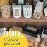 Etichette personalizzate mostrate su confezioni varie, dispose in scaffali. Scritta da 600 pz stampa piu colori