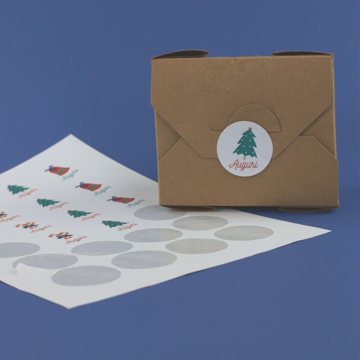 Foglio con etichette tonde adesive personalizzate con auguri ed una etichetta apposta su pacco