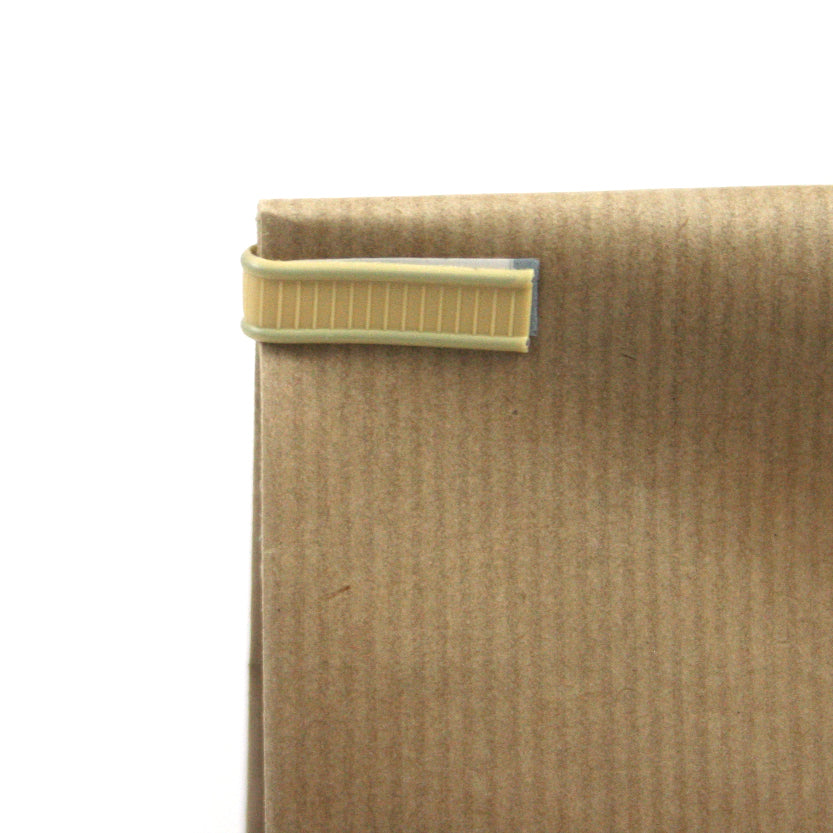 Dettaglio di fascetta chiudi pacco su una busta di carta color avana