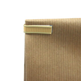 Dettaglio di fascetta chiudi pacco su una busta di carta color avana