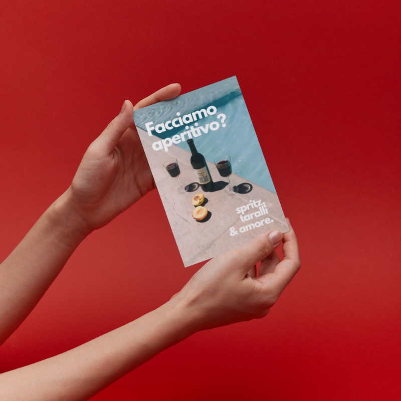 Mani che reggono un flyer su sfondo rosso