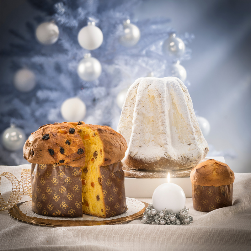Panettone e pandoro su tavola con ambientazione natalizia