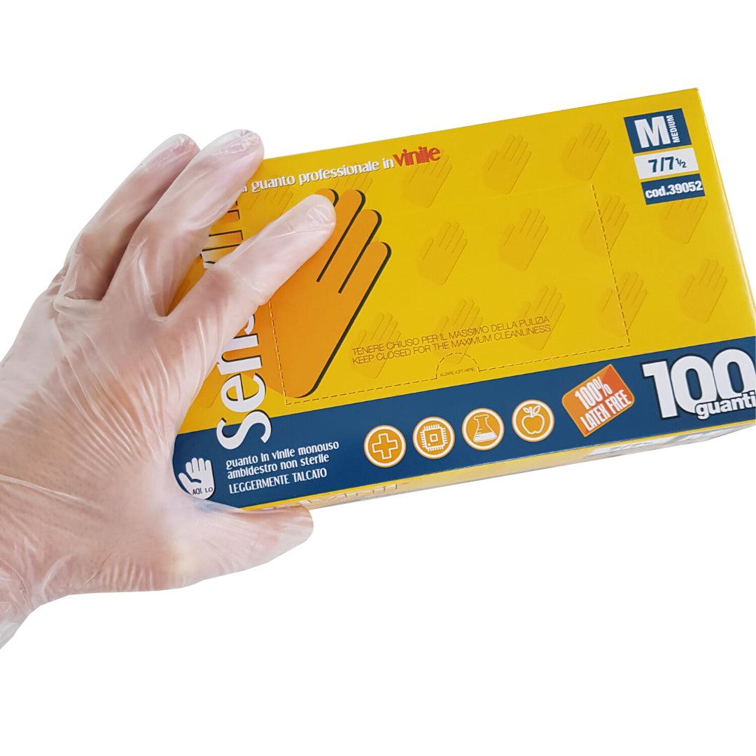Mano con guanto che tiene confezione di guanti in vinile monouso 