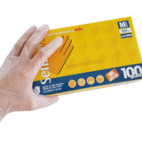 Mano con guanto che tiene confezione di guanti in vinile monouso 