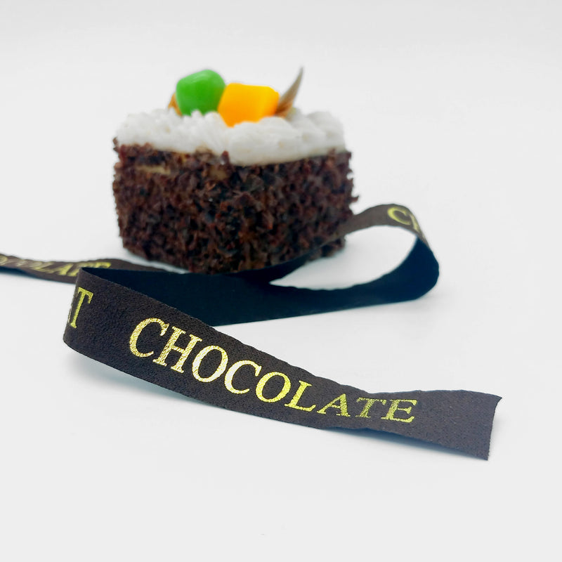 Nastro marrone con scritta dorata CHOCOLATE, accanto ad un tortino