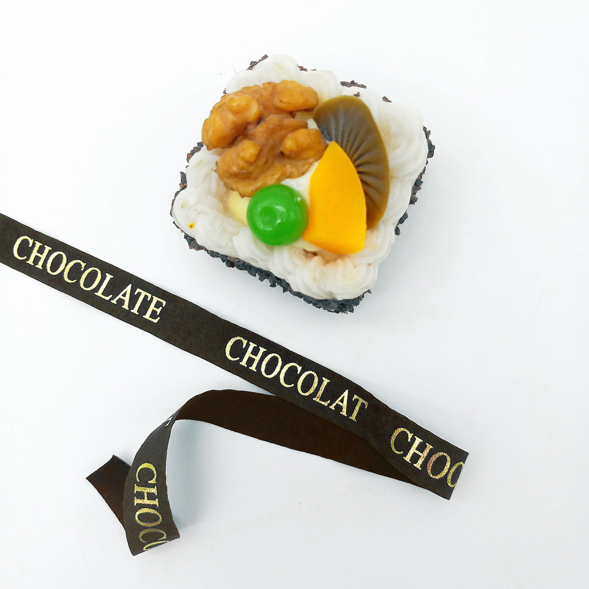 Nastro marrone con scritta dorata CHOCOLATE, accanto ad un tortino