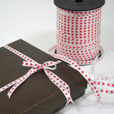 pacco marrone chiuso con nastro bianco con cuoricini rossi 