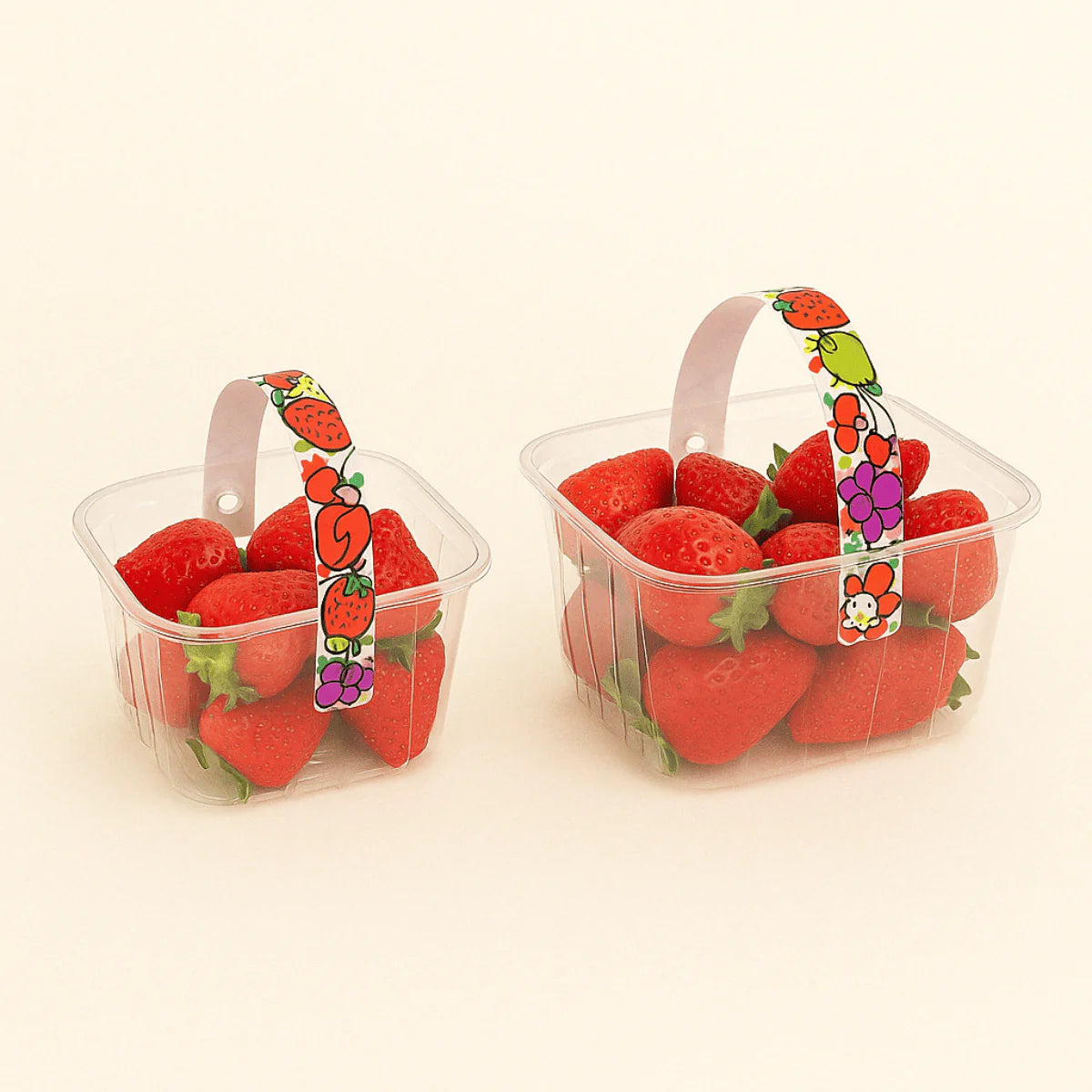 Cestelli per frutta, trasparenti, con manico con grafiche, ripieni di fragole