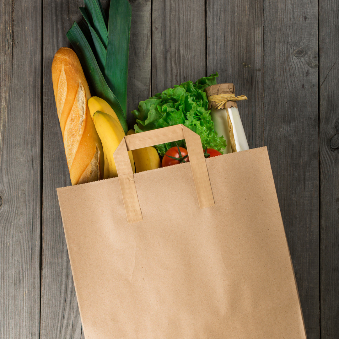 Shopper di carta color avana ripiena di spesa su tavolo
