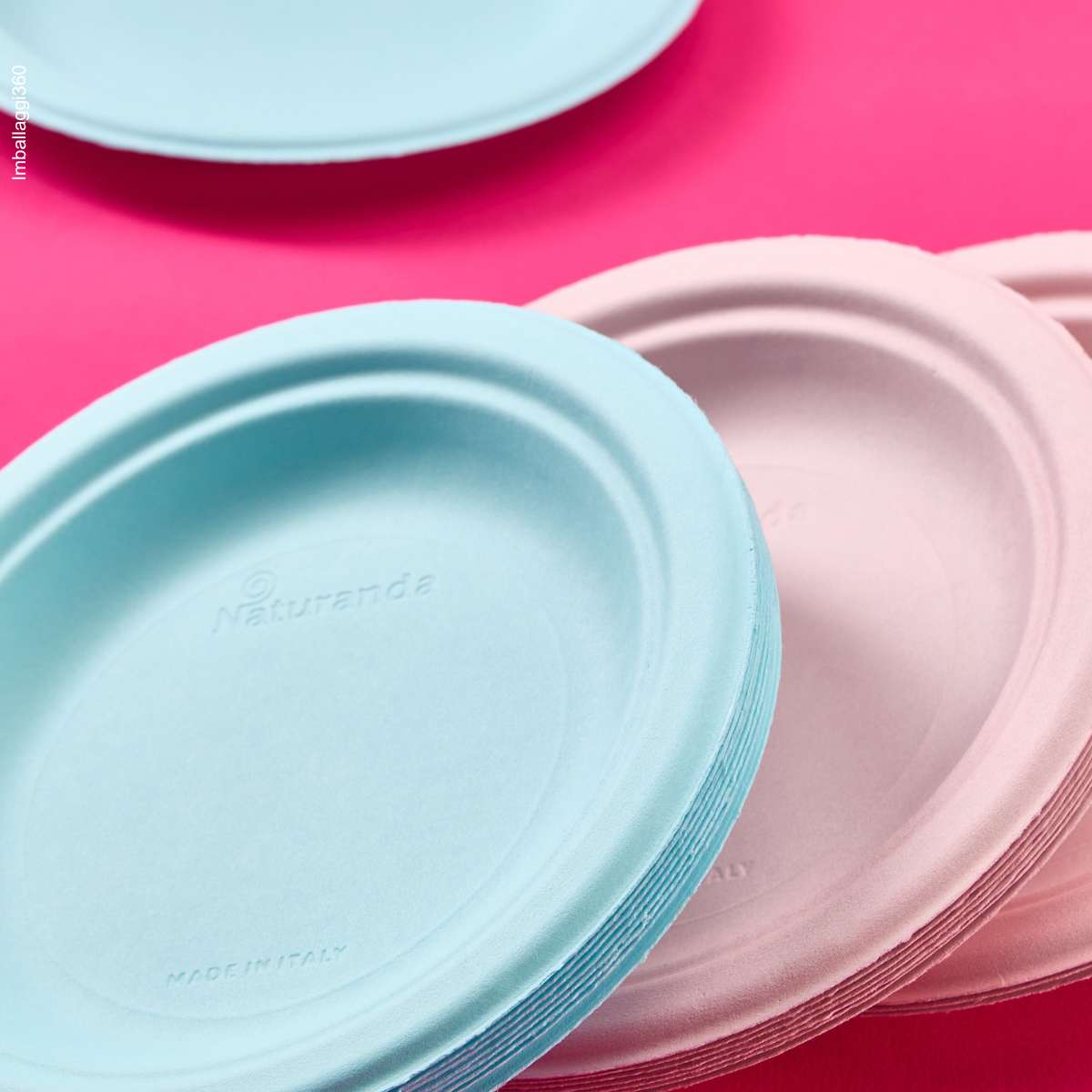 Piatti bio monouso color rosa e azzurro. In primo piano dettagli