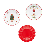 Tre piattini di carta monouso a tema natalizio: uno rosso, uno bianco con un albero di natale e decorazioni ed uno con Merry Christmas trai decori 
