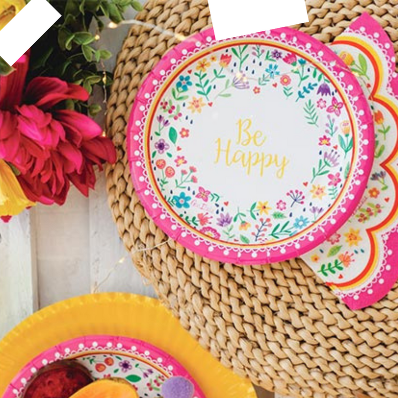 Piatto di carta monouso fantasia Be Happy su tavola imbandita e fiori