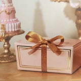 scatoletta rosa con fiocco dorato sutavolino
