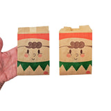 Sacchetti per alimenti color avana, con stampe natalizie, due diverse misure retto da una mano