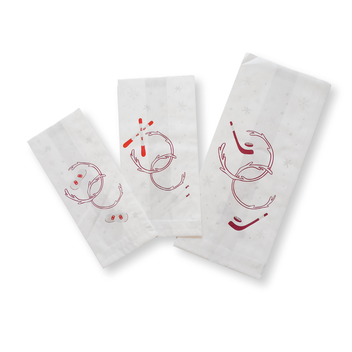 Tre sacchetti di carta bianca con simboli natalizi 