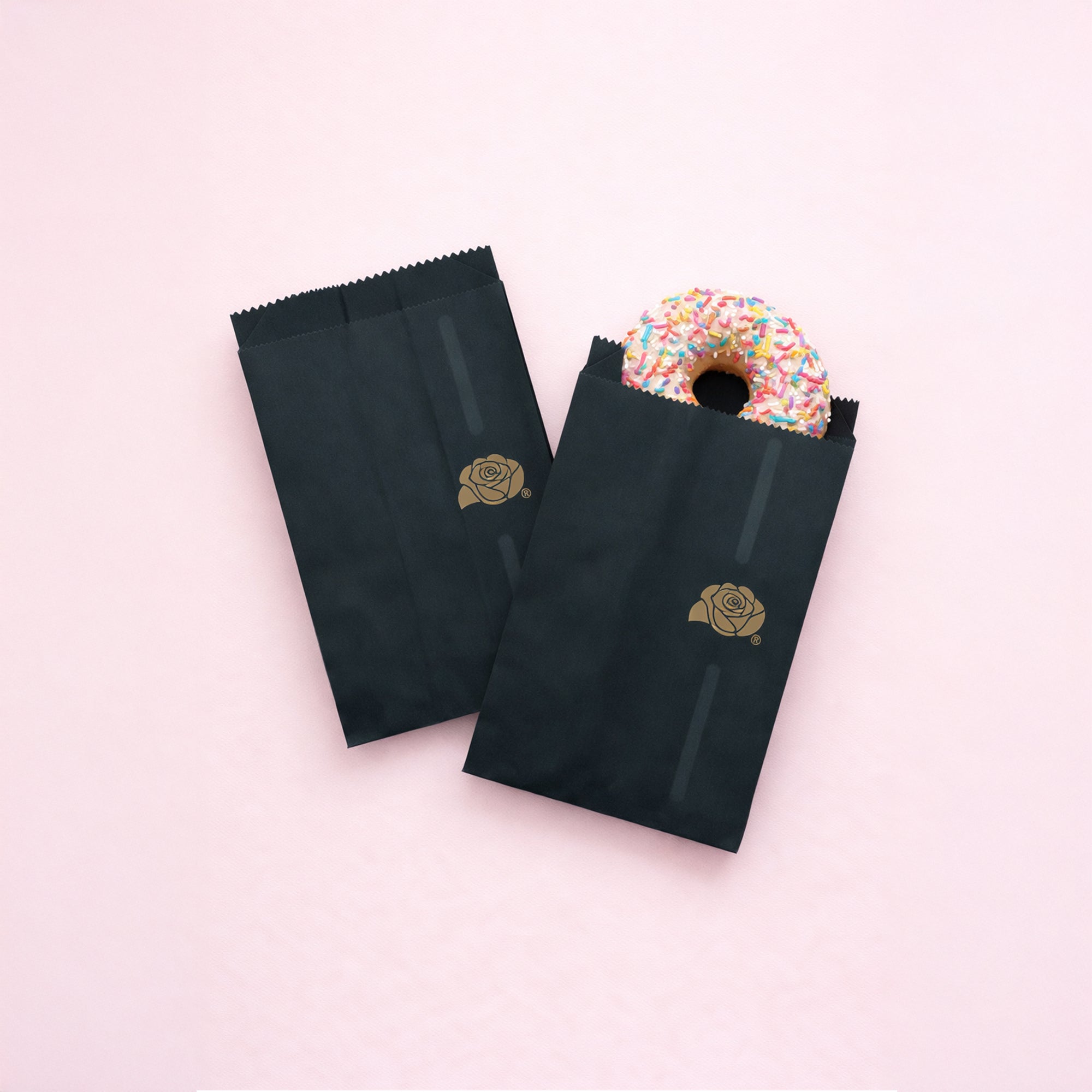 Sacchetti, due, di carta neri, uno vuoto ed uno con una donut colorata