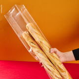 Sacchetto microforato , mostrato con del pane, dentro, retto da una mano. Sfondo rosso