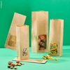 Sacchetti coloro avana con finestra, per biscotti, diverse dimensioni: uno pieno con biscotti, uno con pasta, uno con frutta secca ed uno vuoto. Sfondo verde