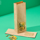 Sacchetto color avana di carta con finestra porta alimenti, mostrato con cibo all'interno ma anche vuoto steso, su sfondo verde