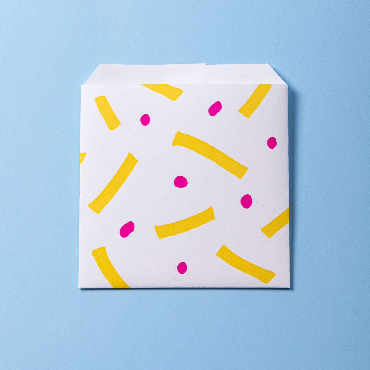 Sacchetto di carta antigrasso  per patatine da sporto, quadrata monoporzione, bianca con disegni gialli e viola 