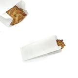 Sacchetto di carta bianco con dentro una brioche mostrato sull'apertura e da sopra