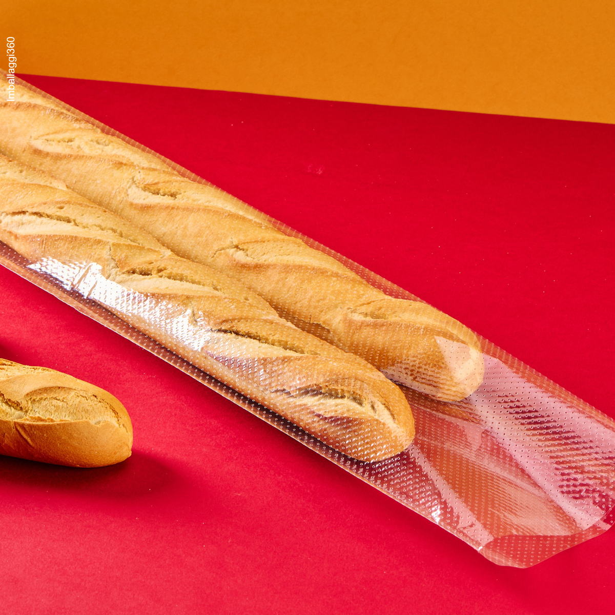 Sacchetto microforato , mostrato con del pane, dentro, dettaglio steso. Sfondo rosso