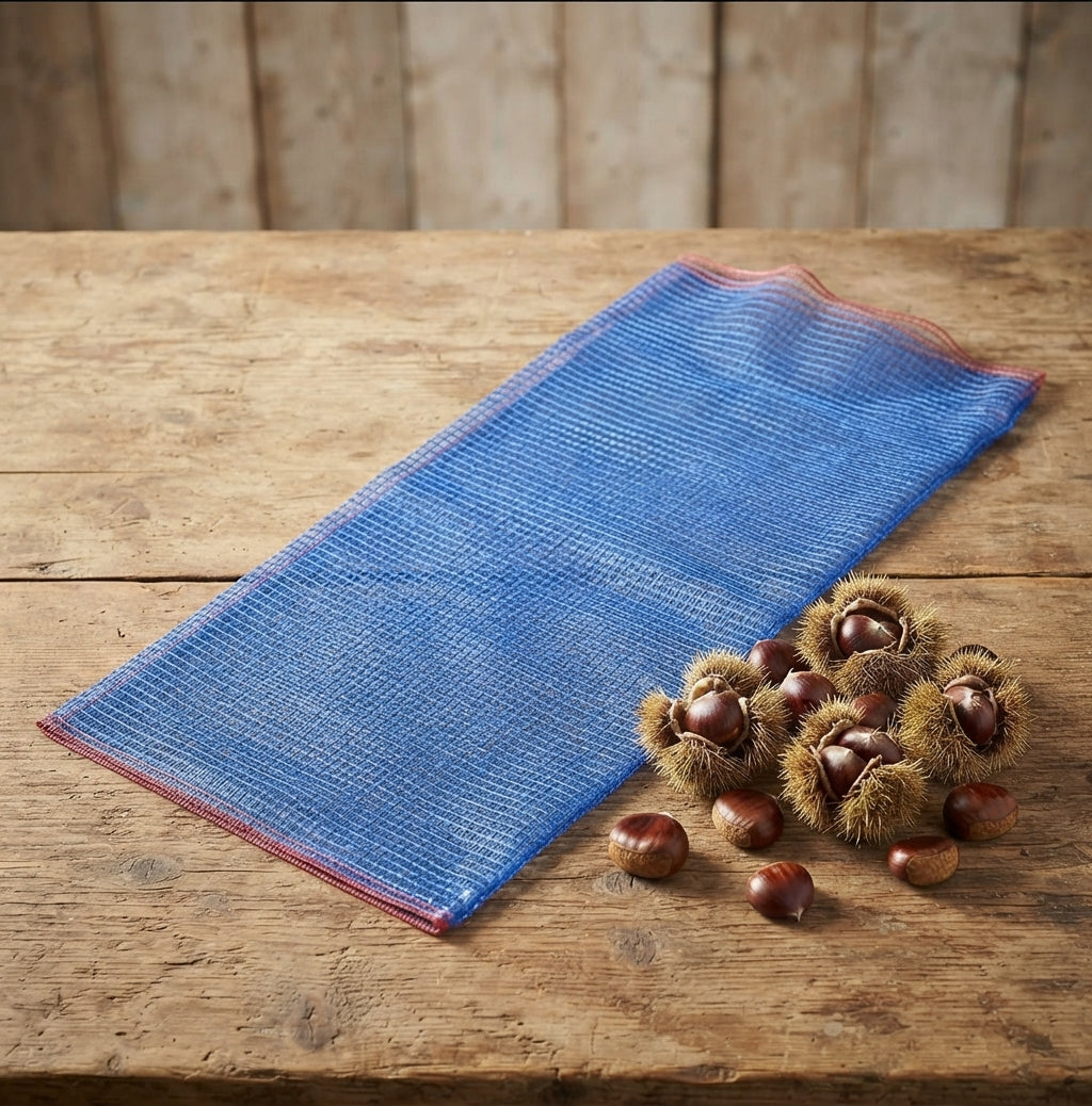 Sacchetto a rete blu per castagne steso appoggiato su un tavolino con accanto dei marroni 