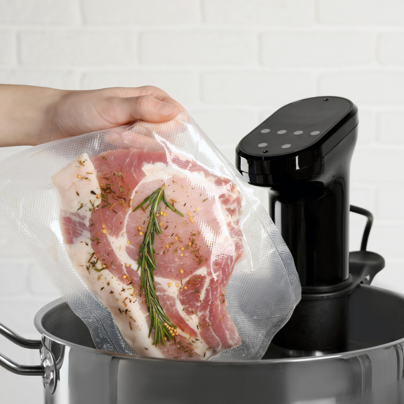 Sacchetto sottovuoto on carne dentro retto da una mano