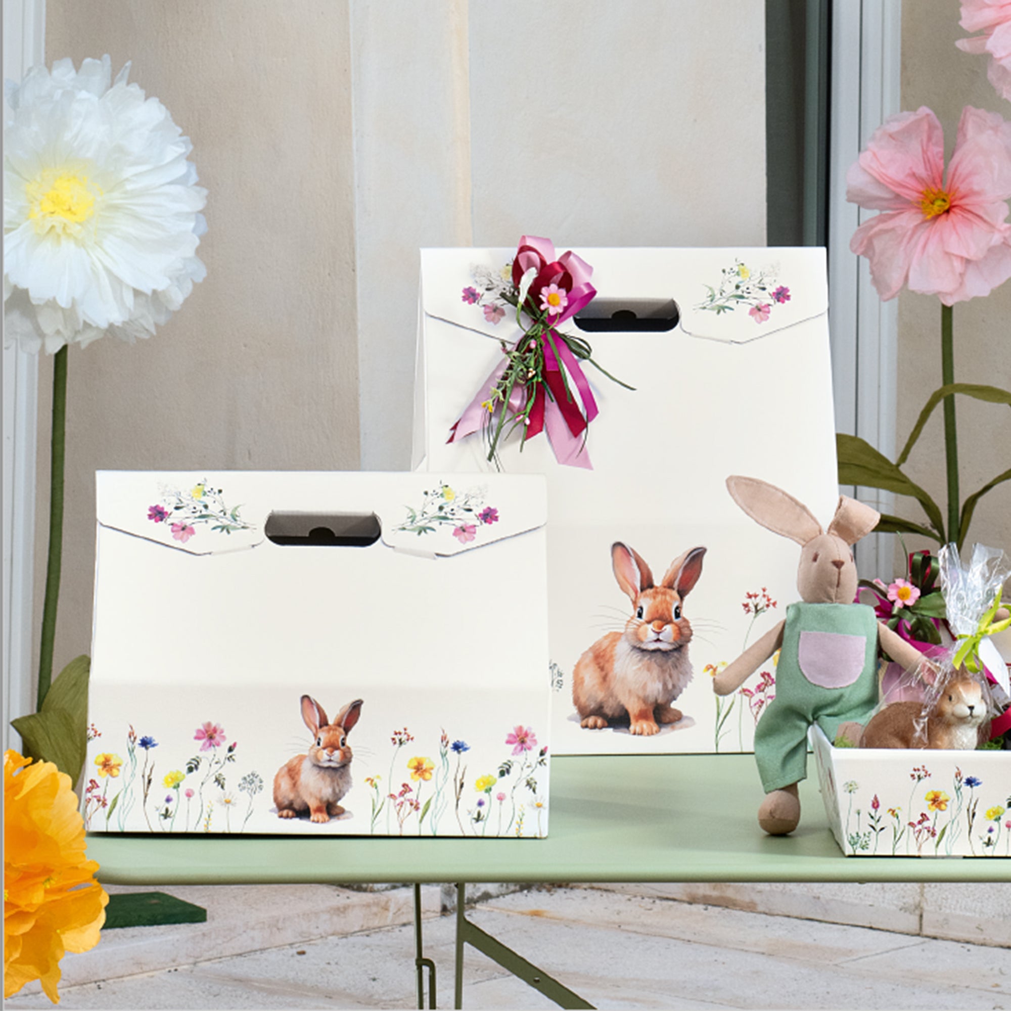 Scatola baulotto con fantasia primaverile pasquale allestita su tavolo con peluche a forma di coniglio 