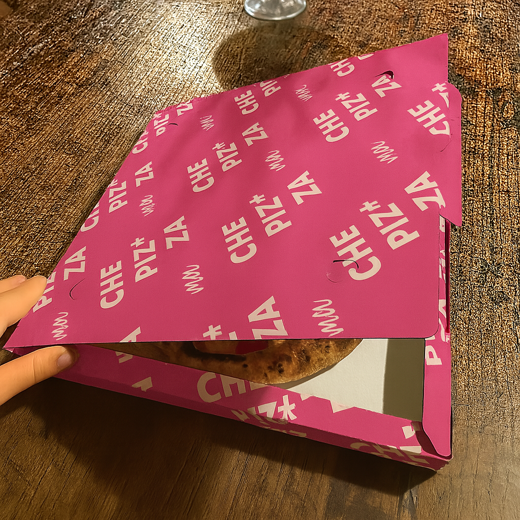 Scatola pizza color fucsia su tavolo di legno, semiaperta
