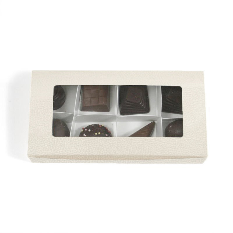 Scatola bianca con finestra e scomparti vista dall'alto piena di cioccolatini 