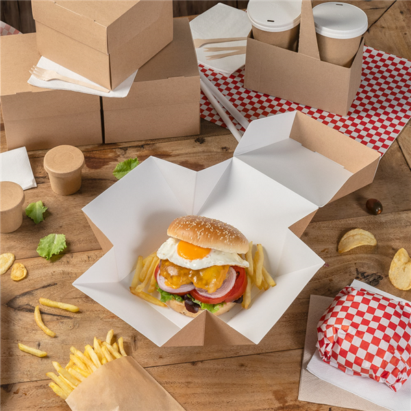 Scatola per hamburger aperta su un tavolino, tra altre con un panino dentro