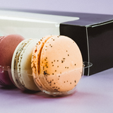 Dettaglio di macarons vicino alla scatola nera porta macarons