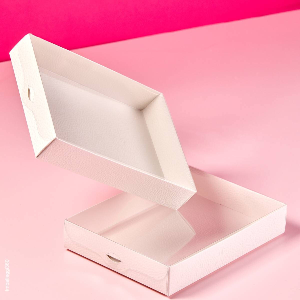 Scatola per alimenti bianca con coperchio trasparente su sfondo fotografico rosa